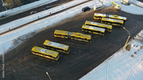 Bus terminus. Bus depot in winter. Buses covered in snow. Yellow bus. Lots of yellow buses. Public urban transport in winter. Frozen buses.