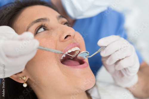 Medical checkup oral cavity of female patient with dental instruments - mirror and probe