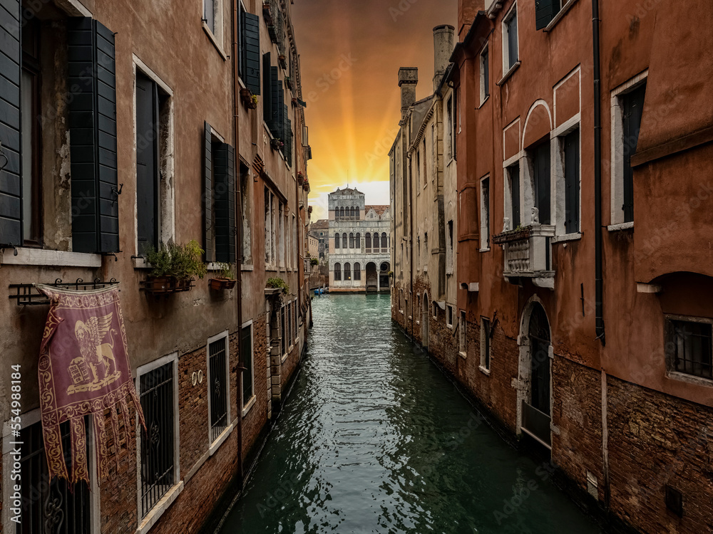 Typical canal of Venice with San Marco flag