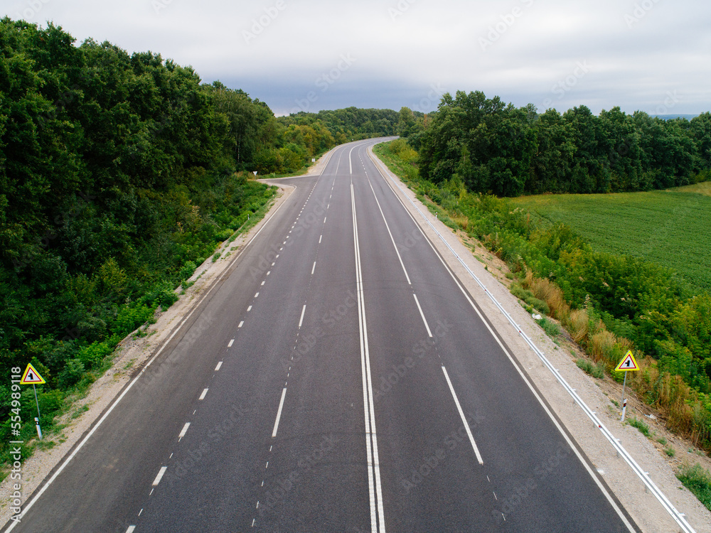 Aerial view asphalt road and green forest, Forest road going through forest with car adventure view from above, Ecosystem and ecology healthy environment concepts and background. Aerial view asphalt road and green forest, Forest road going through forest with car adventure view from above, Ecosystem and ecology healthy environment concepts and background.