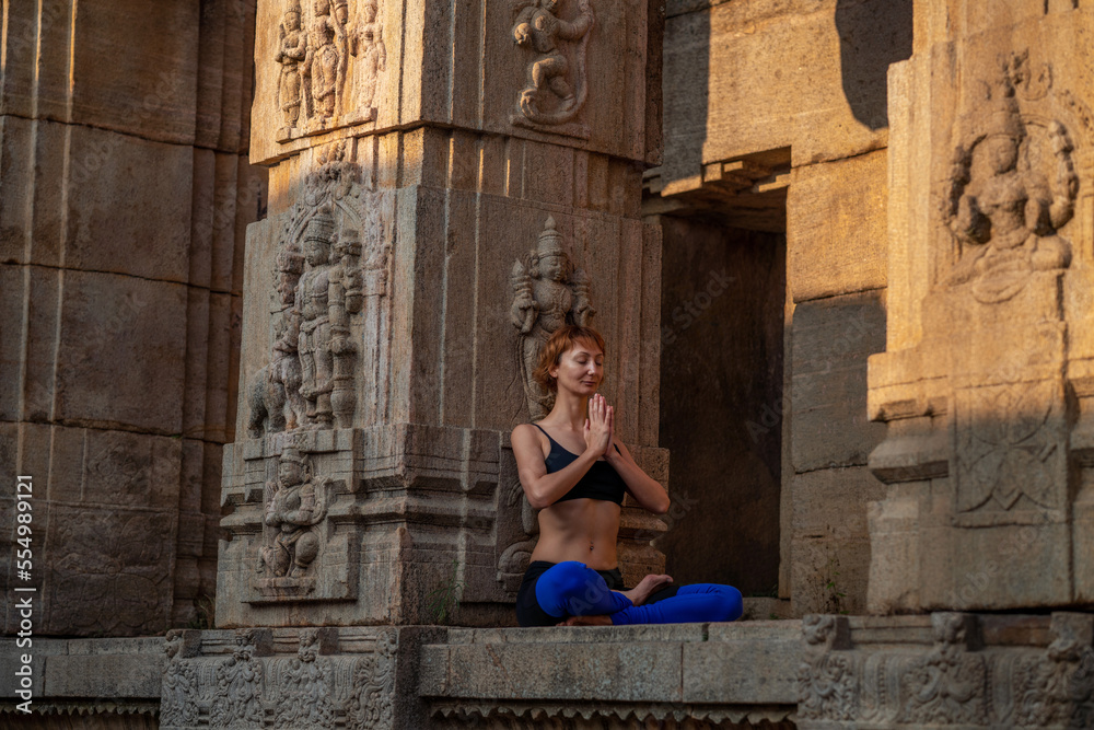 Yogini near an ancient Greek Indian temple. Mindful yoga practice. Namaste. Sun Salutation.