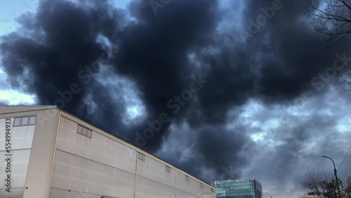 Black, dense and thick column of smoke in the sky during a fire, a fire in a warehouse, poisonous smoke air pollution