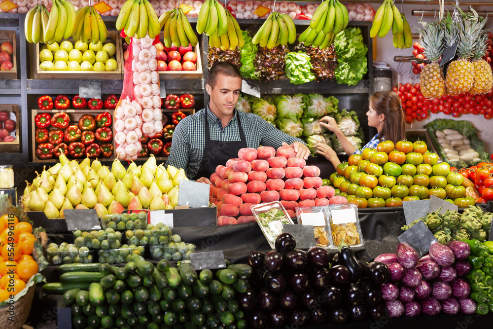Portrait of male and female shop assistants working responsibly in a fruit and vegetable shop