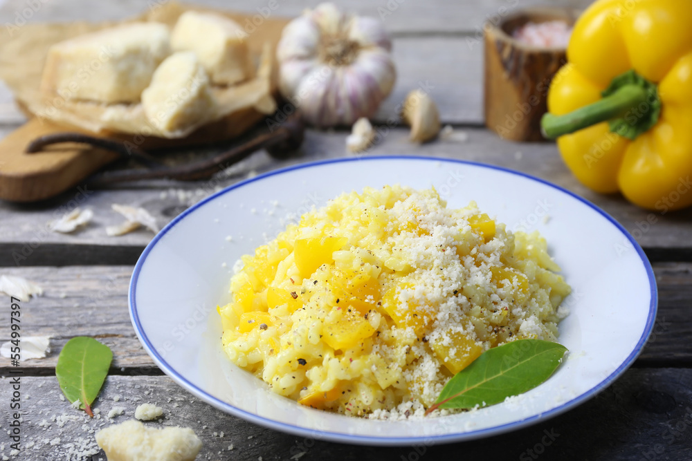 Italian food. Plate of yellow bell pepper risotto and grated parmesan cheese Italian food. Plate of yellow bell pepper risotto and grated parmesan cheese
