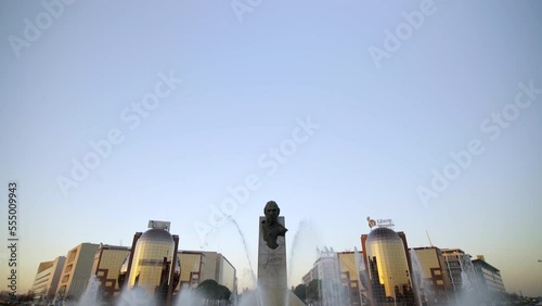 King Juan Carlos I Statue at the Madrid Fairgrounds IFEMA, big head over water pool and fountains besides the big buildings at the exit of Madrid during a beautiful sunset at the Capital of Spain photo