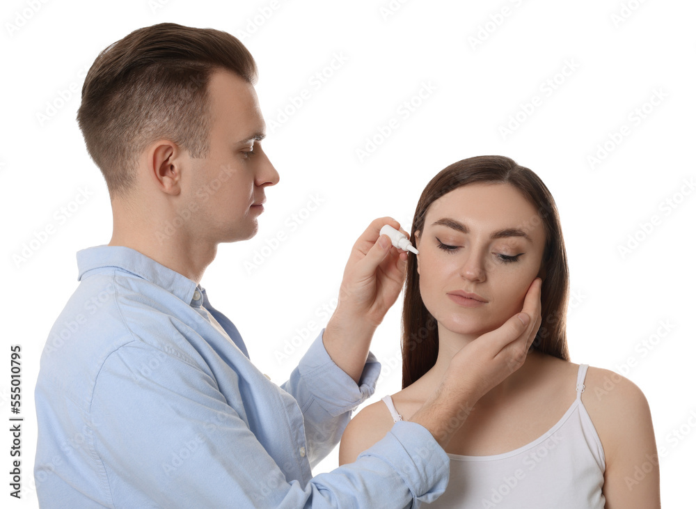 Man dripping medication into woman's ear on white background Man dripping medication into woman's ear on white background
