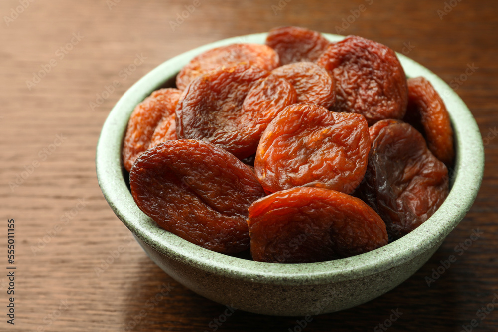 Bowl of tasty apricots on wooden table, closeup. Dried fruits Bowl of tasty apricots on wooden table, closeup. Dried fruits