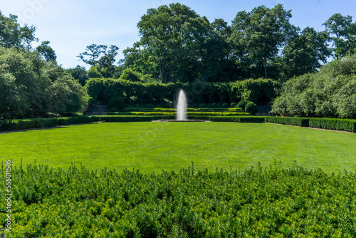 New York, NY - USA - July 20, 2018 View of Conservatory Garden's symmetrical lawn with a single central fountain jet at the rear, is a formal garden near Central Park's northeast corner. photo