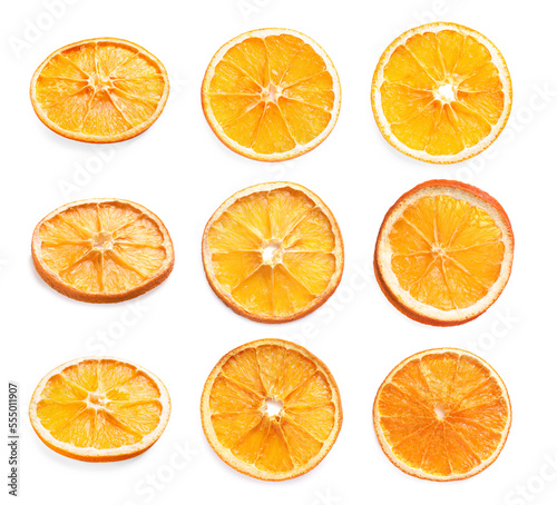 Many dry orange slices on white background