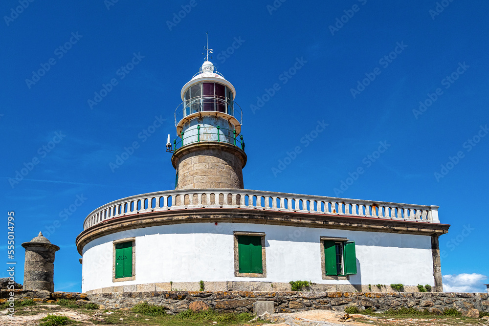 Corrubedo lighthouse in the Atlantic Ocean, Galicia, Spain. Lighthouse on top of a rock crag