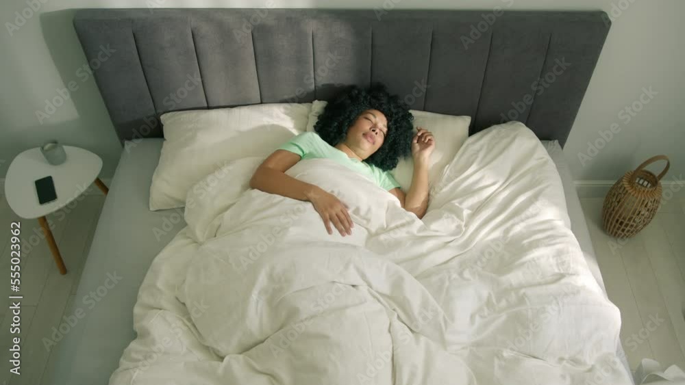 Peaceful serene girl resting lying asleep enjoying good sleep in morning. Calm young African American woman sleeping well in comfortable cozy fresh bed on soft pillow white linen orthopedic mattress Peaceful serene girl resting lying asleep enjoying good sleep in morning. Calm young African American woman sleeping well in comfortable cozy fresh bed on soft pillow white linen orthopedic mattress