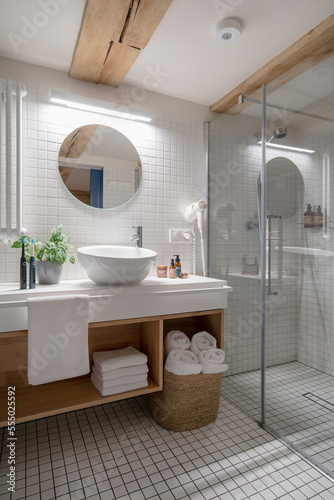 Wide shower cabin in white tiled bathroom