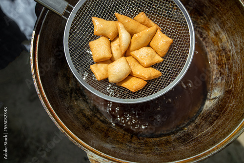 Traditional Kazakh and central asian fresh baursaks are taken out of a large cauldron. Traditional appetizer for Nauryz holiday. photo