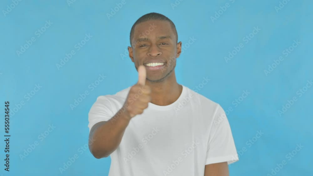 Thumbs Up by African Man on Blue Background Thumbs Up by African Man on Blue Background