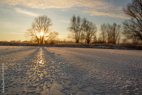 Breath of winter, first ice on the lake, dawn on a frosty morning with frost on the grass, close-up of frost, patterns on the first ice