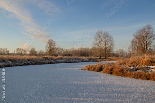 Breath of winter  first ice on the lake  dawn on a frosty morning with frost on the grass  close-up of frost  patterns on the first ice