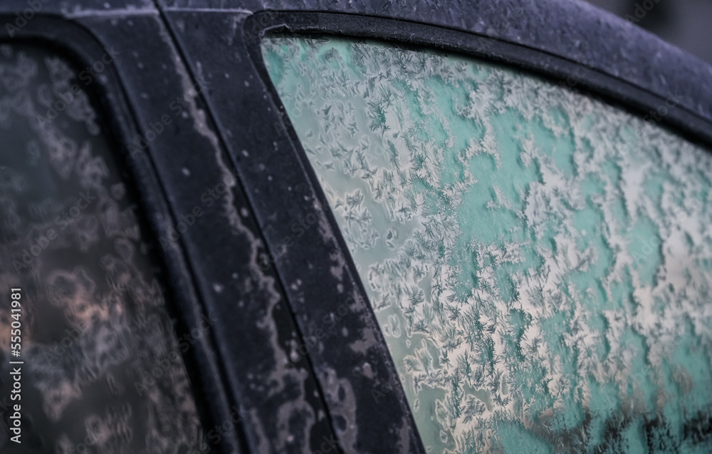 Freezing winter temperatures. Close up view with a frozen car parked outside during a freezing morning.