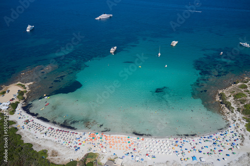 Aerial top view on sand beach. Umbrellas, sand and sea. Beach in sardinia top view.