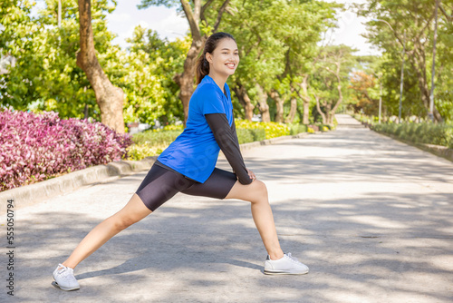 Asian woman stretching her legs before running