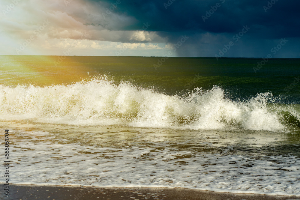 Sea waves crash on the sandy shore in bad weather. Small waves on the sandy beach. Sea waves crash on the sandy shore in bad weather. Small waves on the sandy beach.