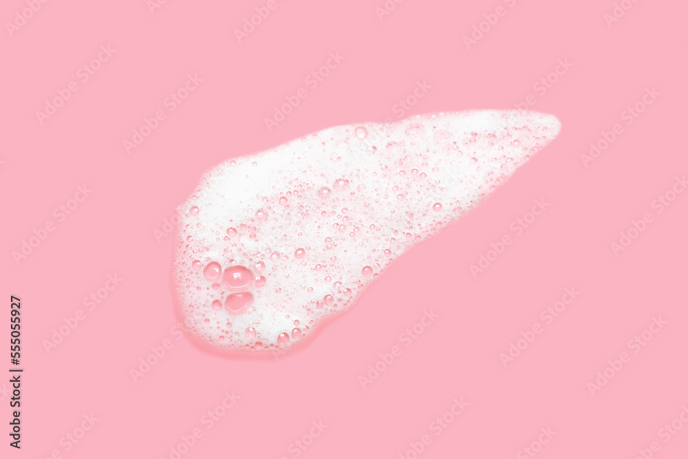 Fototapeta premium Smear of facial cleansing foam on pink background close-up.