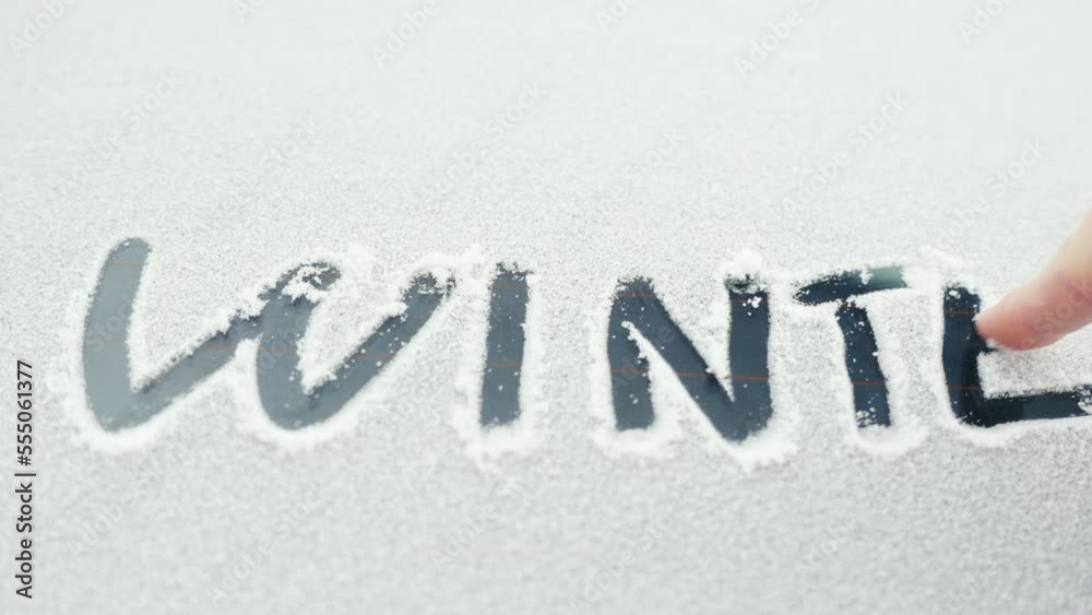 Winter written in snow on car windscreen, cold weather season Winter written in snow on car windscreen, cold weather season