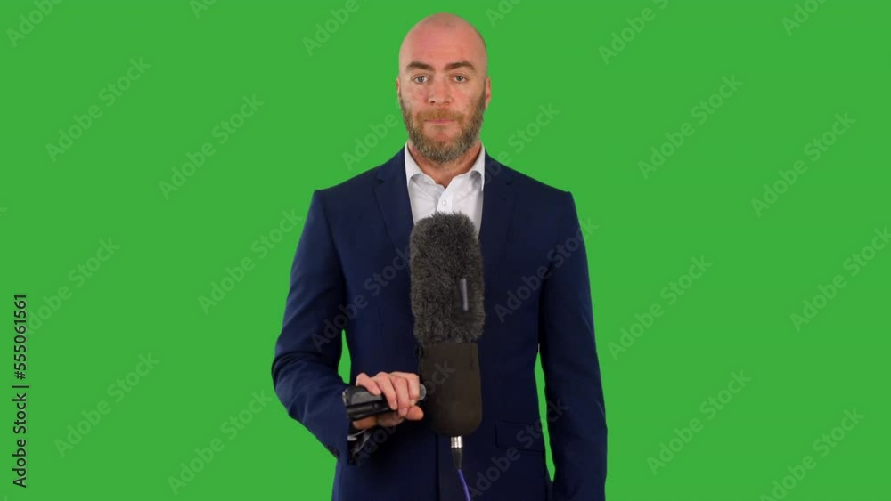 A male newspresenter with a microphone presenting news on the television with green screen background A male newspresenter with a microphone presenting news on the television with green screen background
