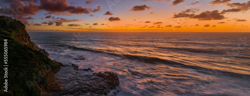 Surfs up sunrise at the seaside with scattered clouds