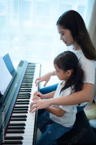 Family vacation, other helping daughter practice in her piano lessons