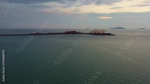 Aerial drone flyover straits of malacca, sea in west coast Malaysia capturing the export wharf of brazilian vale iron ore mining corporation, logistic bulk teluk rubiah terminal at dusk. photo