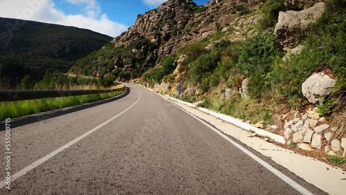 Cyclist riding bicycle uphill in mountains, POV shot. Cycling and triathlon