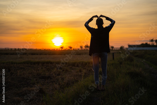 Asia Girl Stand in Feild  silhouette of a person in the sunset