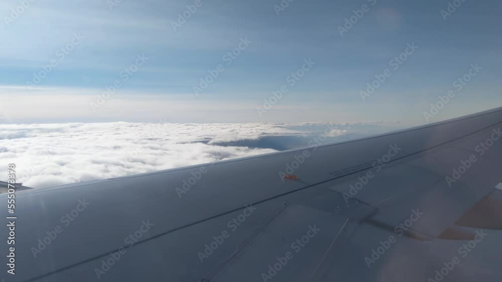 View of the clouds and the wing from the airplane window. Flight. Air travel