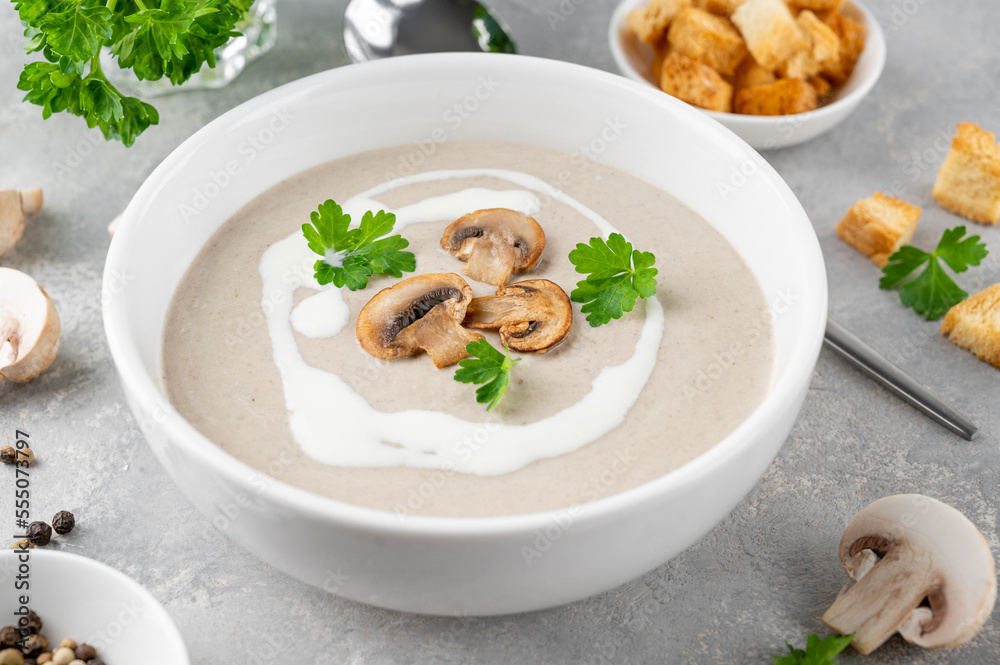 Mushroom cream soup with cream, croutons and herbs on a white wooden background. Delicious comfort food. Mushroom cream soup with cream, croutons and herbs on a white wooden background. Delicious comfort food.