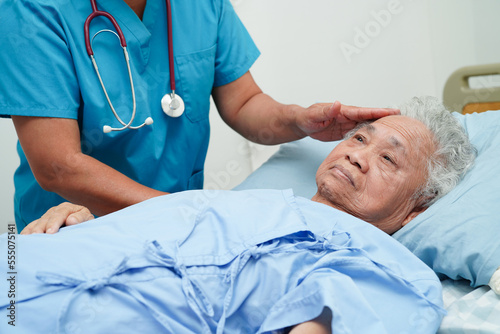 Asia doctor with stethoscope checking elderly woman patient in hospital, healthy medical concept.