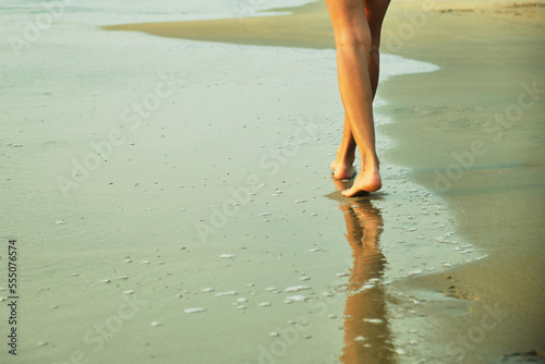 Feet on the beach near the sea. 