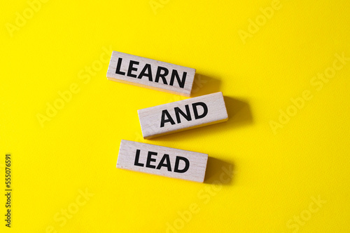 Learn and lead symbol. Concept words 'Learn and lead' on wooden blocks. Beautiful yellow background. Business and Learn and lead concept. Copy space.