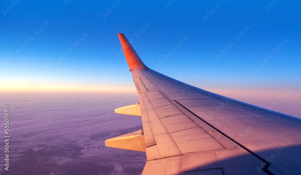 Panoramic cabin view through of an airplane window. Aircraft flight above land and blue sky with space for text Panoramic cabin view through of an airplane window. Aircraft flight above land and blue sky with space for text