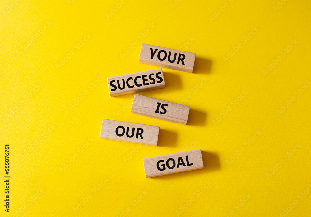 Your success is our goal symbol. Wooden blocks with words Your success is our goal. Beautiful yellow background. Business and Your success is our goal concept. Copy space