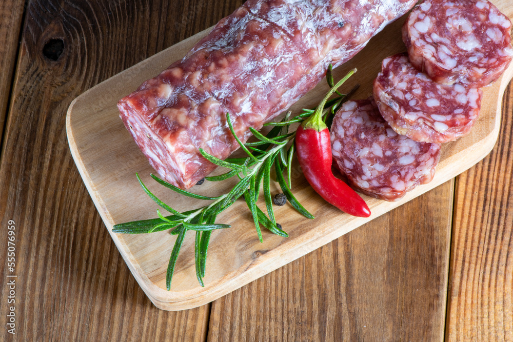 cutting board with sliced salami on it. cutting board with sliced salami on it.