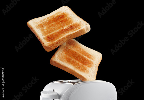 Roasted toasts popping out of toaster, isolated on black background