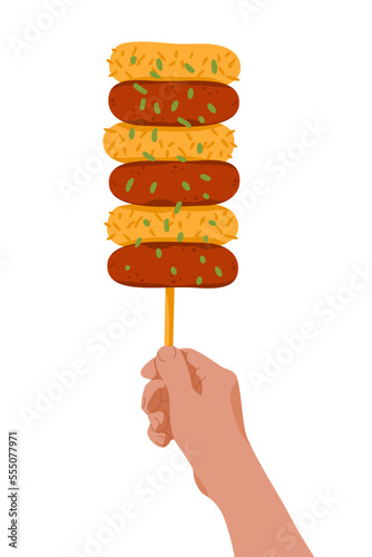 Hand with rice cake skewers on stick. Korean street food Sotteok Sotteok. Fried sausages rice cakes on stick in turns.