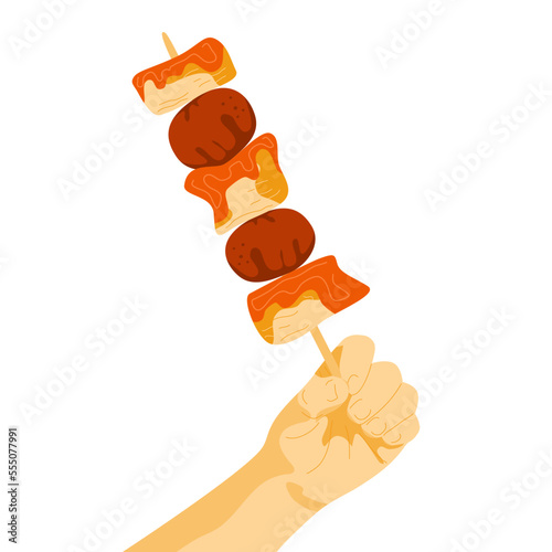 Human hand with chicken skewers on stick. Korean street food ddakkochi. Chicken and tomatos on stick in turns. Asian food snack.