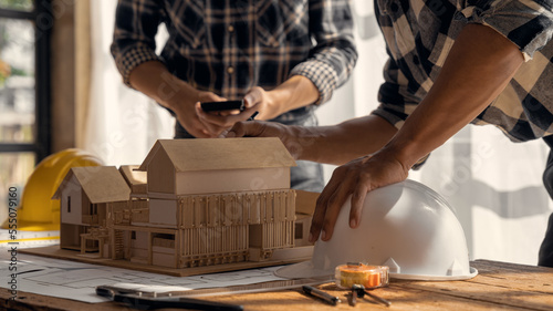 Close up of Engineer teams hands making model house. Engineer teams working in the office.