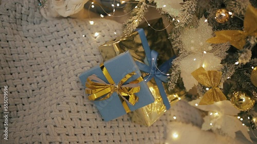 Patriotic wrapped Christmas present boxes under fir tree. National Ukrainian flag colors blue and golden yellow. vertical close up shot