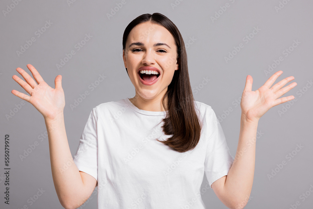 Happy delighted young woman o grey background isolated showing delightful cheering up happy emotions expressions cheering her boyfriend up raising hands. Happy delighted young woman o grey background isolated showing delightful cheering up happy emotions expressions cheering her boyfriend up raising hands.
