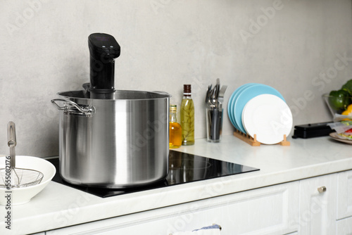 Pot with sous vide cooker in kitchen. Thermal immersion circulator