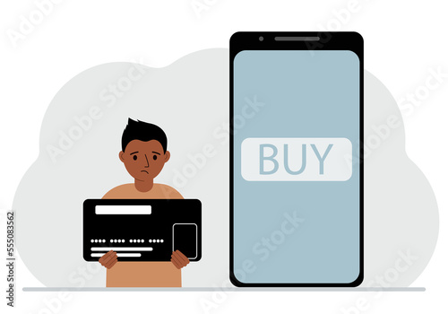 A small boy holds a credit card in his hand and a large mobile phone nearby. The concept of bank payment, online purchase, children's credit card.