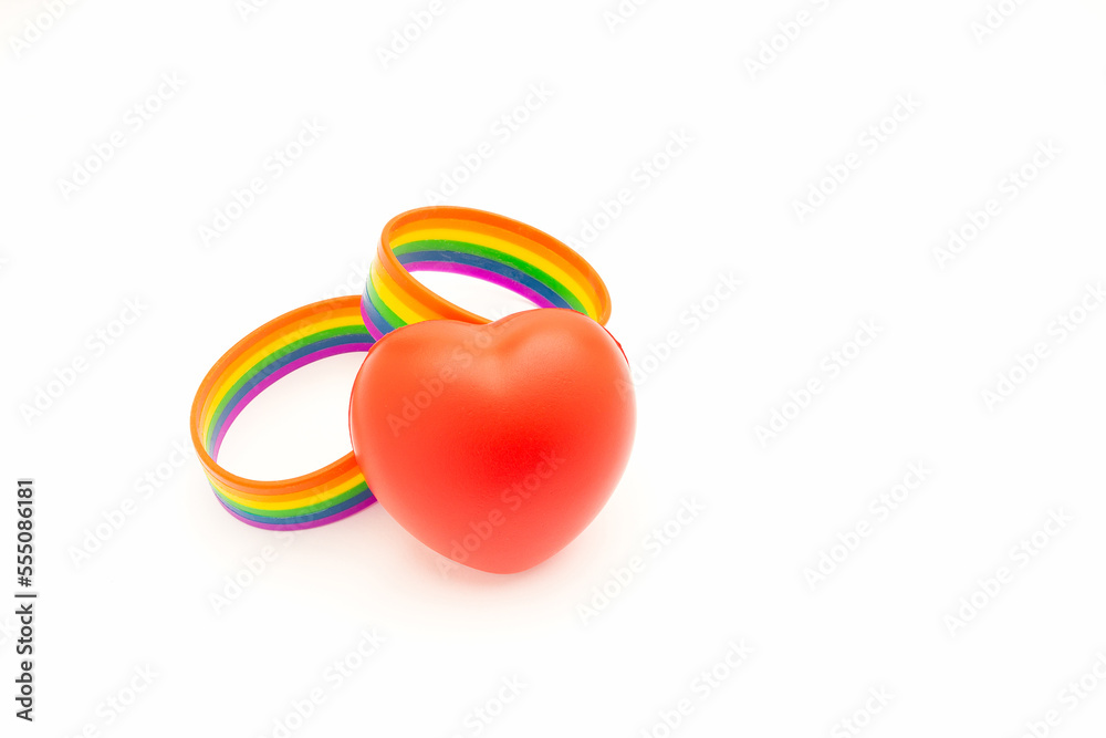 Rainbow patterned wristbands and a red heart shape symbol are on a white background Rainbow patterned wristbands and a red heart shape symbol are on a white background