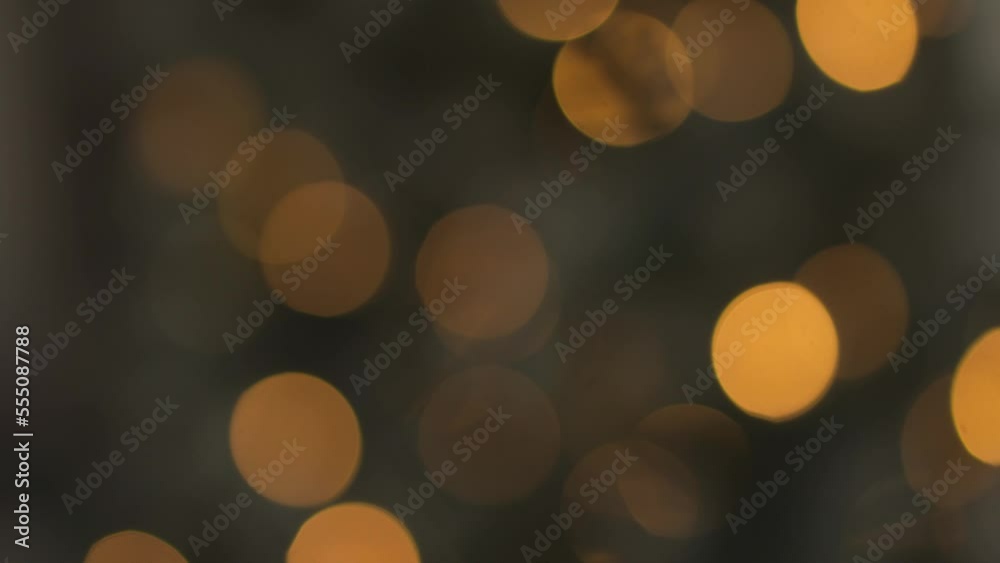Out of focus holiday background. Light bokeh from Xmas tree. New Year theme, background 4k footage. Christmas lights, shimmering abstract golden warm circles defocused. Blurred fairy lights